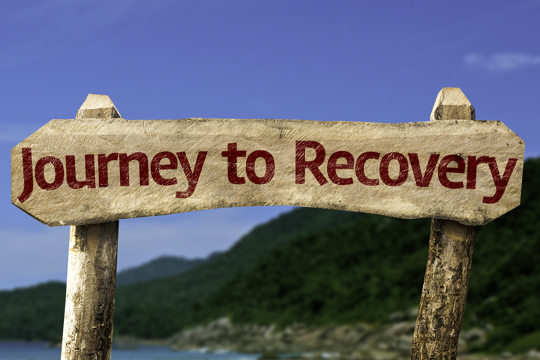 Journey to Recovery wooden sign with a beach on background